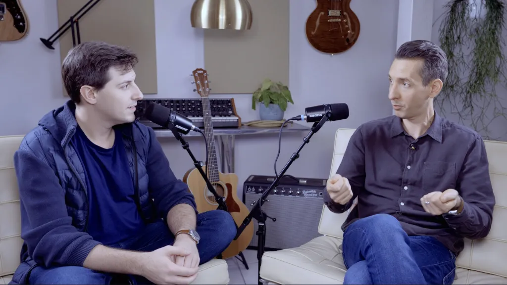 Two people sitting next to each other with microphones